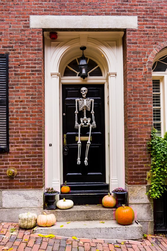 Skeleton and halloween decorations on front door of brick building